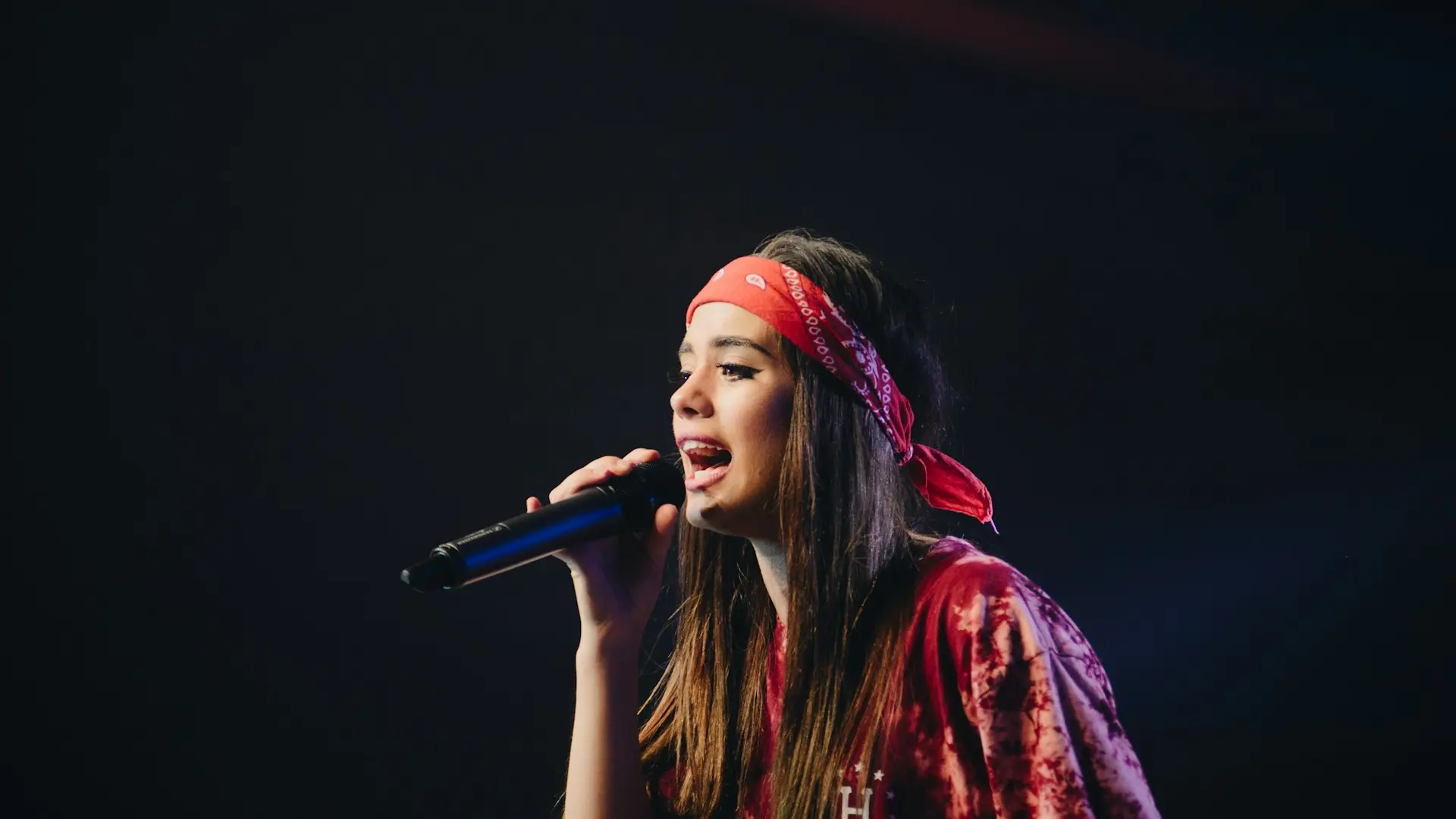 woman in red dress holding microphone